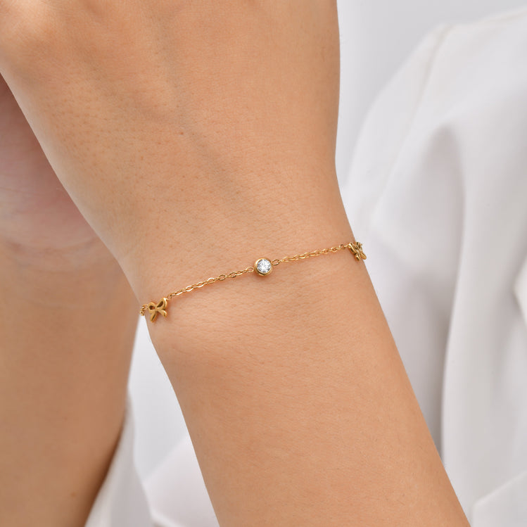 The Jazzy Owl Bow & Glow Bracelet, a delicate gold-tone chain with a bow detail and sparkling center stone