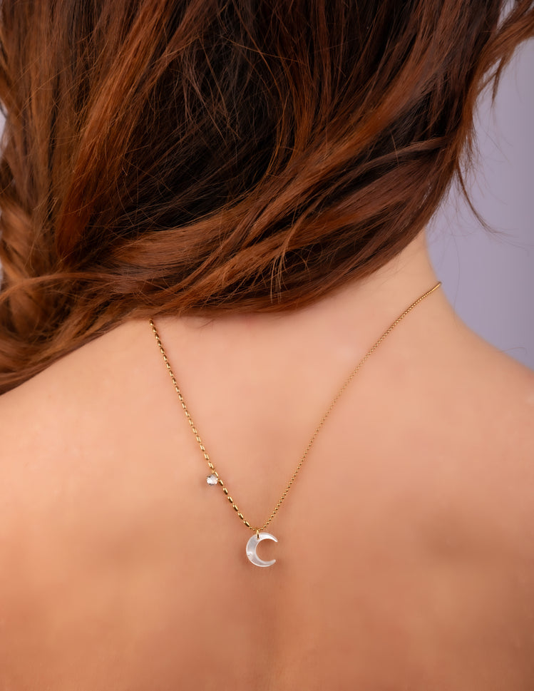 Woman wearing the Moonbeam Babe crescent moon necklace, seen from behind