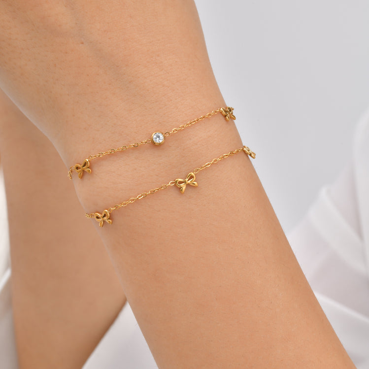 The Jazzy Owl Bow & Glow Bracelet, a dainty gold-tone chain with a bow accent and sparkling center stone